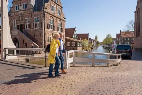 Wandelaars langs historische huizen en water in De Rijp
